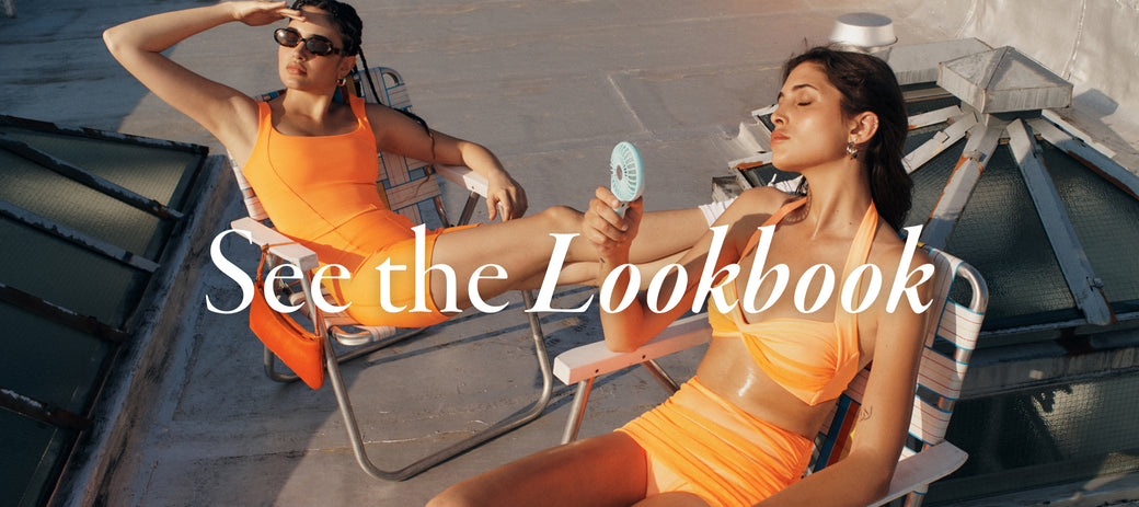 Models wearing orange sets sitting in beach chairs on a roof in New York with the words  See The Lookbook  